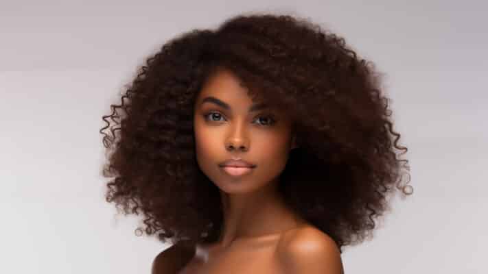Beautiful young black woman with glowing healthy skin close-up. Advertising of cosmetics, perfumes, copy space