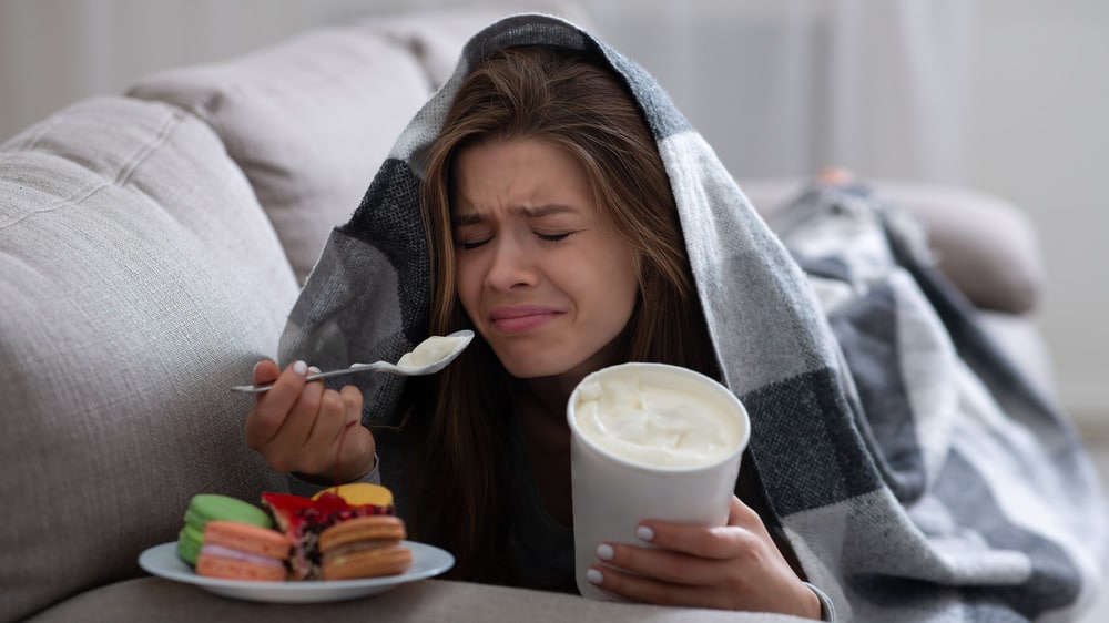 upset young woman eating ice cream